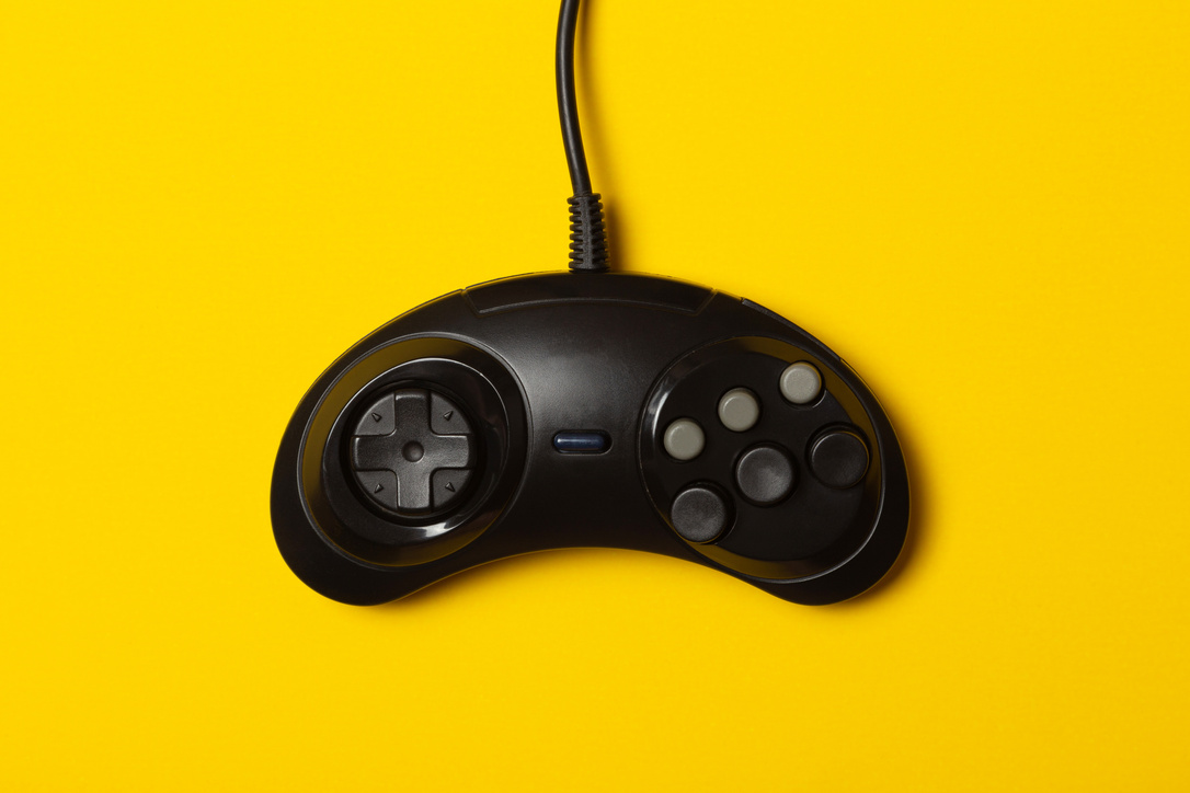 black six-button gamepad against a yellow background